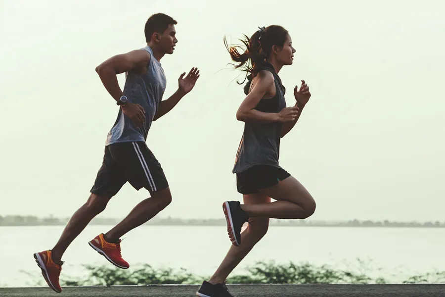 A couple in profile running along the water. Schedule GLP-1 Weight Loss Injections from Tanya Zboril, NP of TBT Medical in Regina.