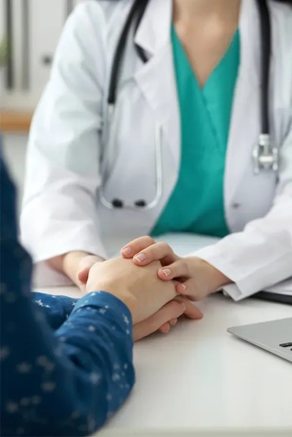 Image of a cheerful man with a bright smile and curly hair against a natural landscape. Tanya Zboril, NP of TBT Medical provides personalized hair loss treatments in Regina.