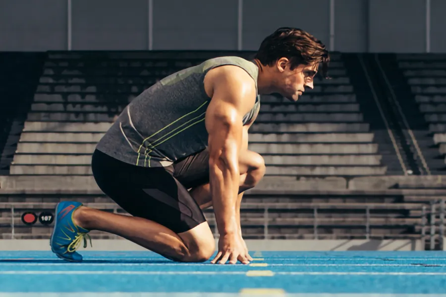 Lean-Muscle-and-Recovery-Clinic A white man kneels at the starting line on a track, determined to do his best. Get treatment for lean muscle loss and recovery from Tanya Zboril, NP of TBT Medical in Regina.