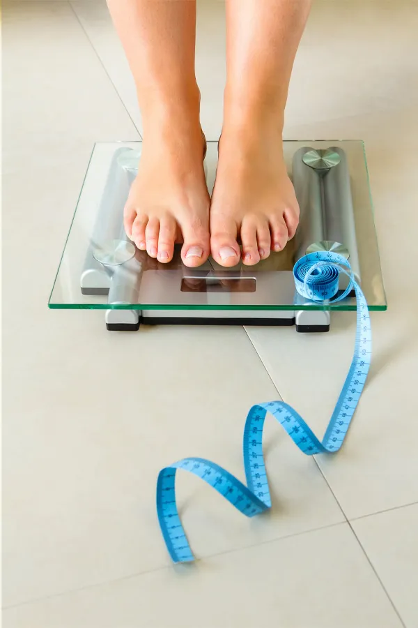 Feet on a scale with a measuring tape for weight loss. Get Ozempic for weight loss from Tanya Zboril, NP of TBT Medical in Regina.