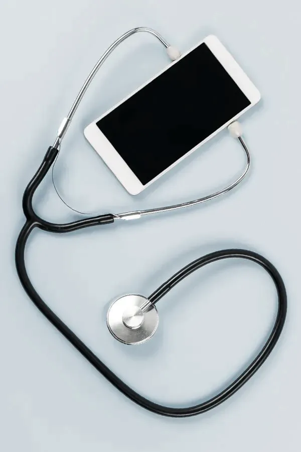 A smartphone with a stethoscope attached to it, symbolizing Telemedicine treatment from Tanya Zboril, NP of TBT Medical in Regina.